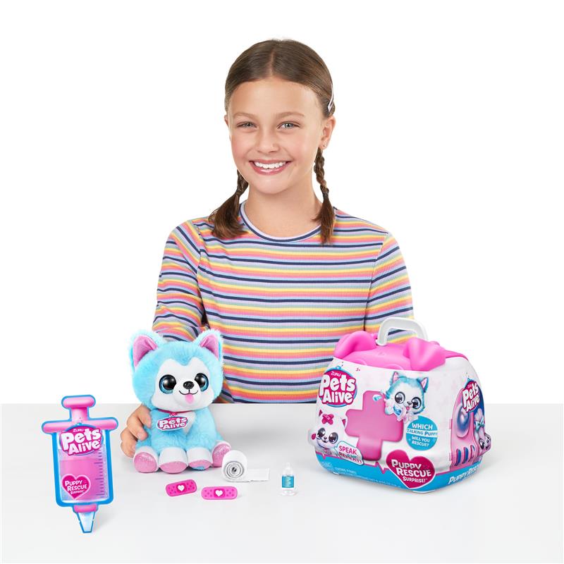 A smiling girl holds a blue and pink plush puppy toy, surrounded by a toy syringe, a pet care kit, and accessories.