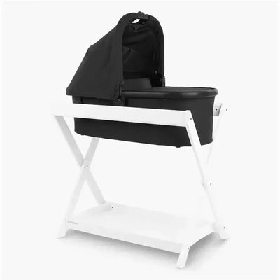 Uppababy bassinet stand in white, featuring a black fabric bassinet with a canopy, designed for infant sleeping.