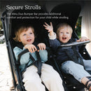 Minu Duo Bumper Bar, saddle color, displayed with two smiling children in stroller, enhancing safety and comfort while strolling.