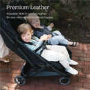 Dual children seated in the UPPAbaby Minu Duo stroller, featuring premium leather seats and a chestnut bumper bar.