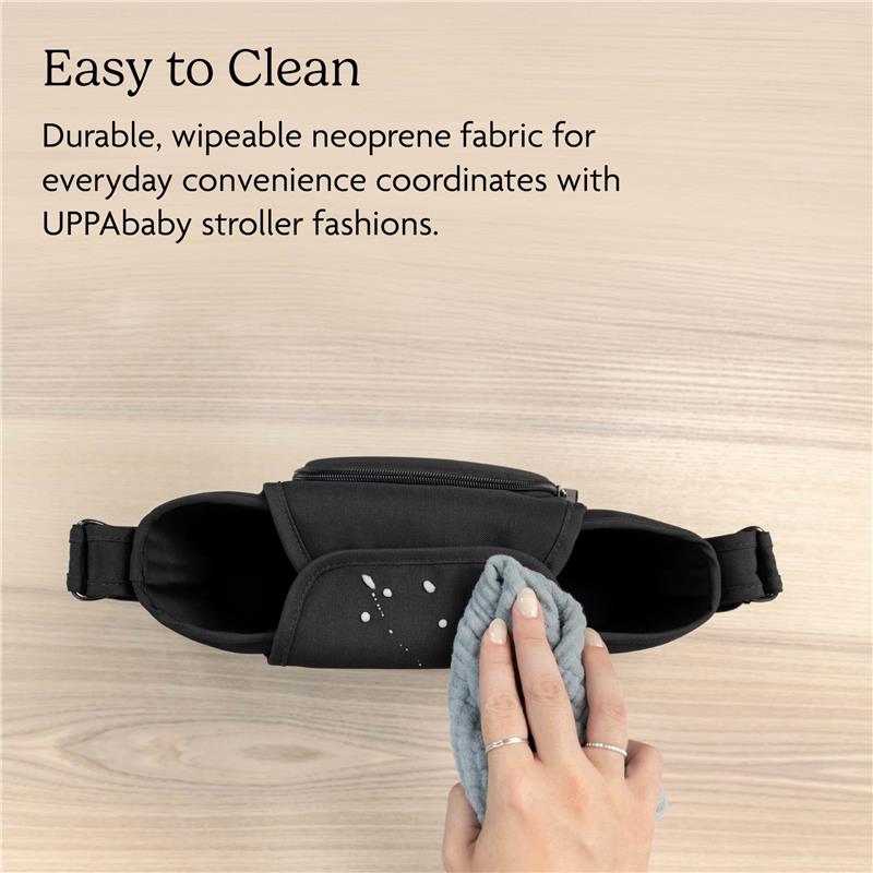 UPPAbaby Carry-All Parent Organizer in charcoal, showing a hand cleaning its durable neoprene fabric with a cloth.
