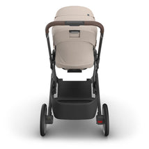 Uppababy Cruz V3 stroller in Sandstone Melange with Chestnut Leather handle, viewed from the back, showcasing the seat and wheels.