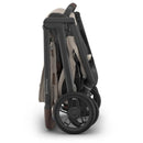 Uppababy Kona Stroller & Bassinet V3 Bundle in Ada (Sandstone Mélange), shown in a folded position with dark wheels.