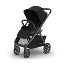 Uppababy Kona Stroller in black with a carbon frame and black leather accents, featuring a spacious seat and canopy.