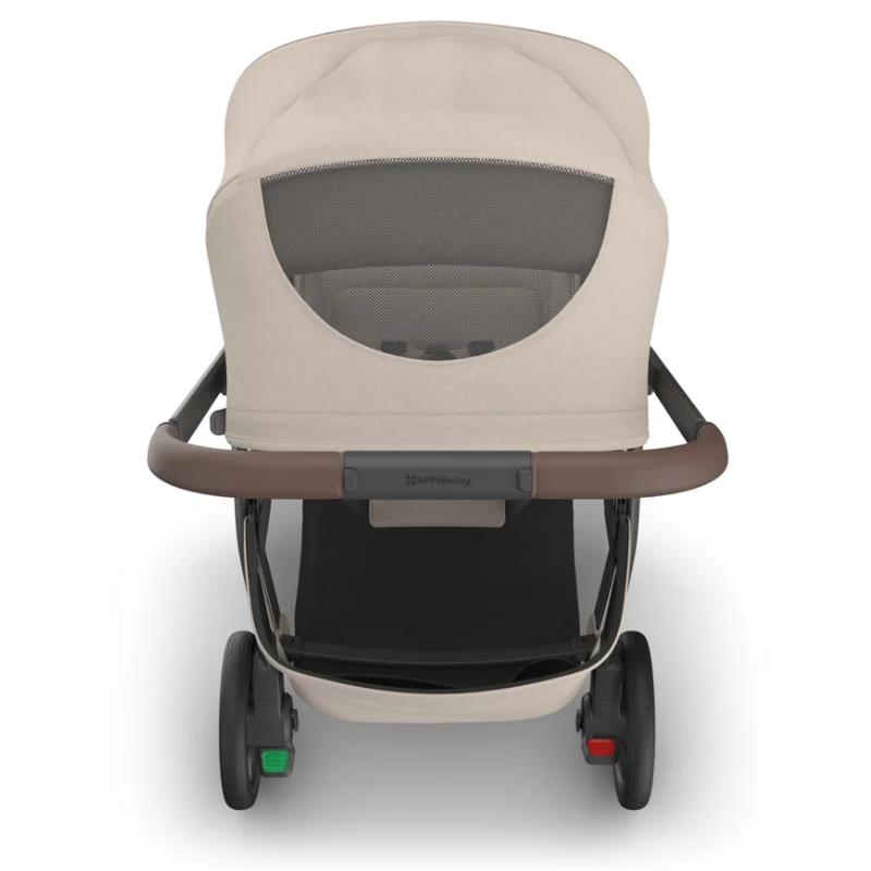 Uppababy Kona stroller with a tan canopy, brown handlebar, and visible safety harness.