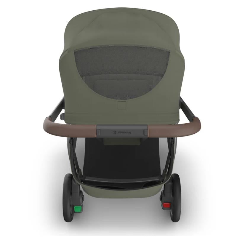Uppababy Kona stroller in Meadow Green, featuring a mesh back and a brown handlebar, with visible wheels and frame.