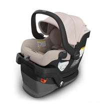 UPPAbaby Mesa V3 infant car seat in Ada color, with a canopy and safety labels, featuring a cream interior and a black base.