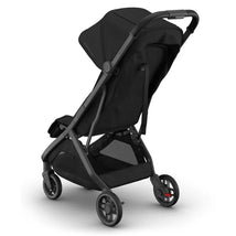 Uppababy Minu V3 compact stroller in black with a carbon frame and black leather accents, angled view showing the seat and wheels.