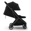 Uppababy Minu V3 compact stroller in black with carbon frame and leather accents, shown in a side view with canopy raised.