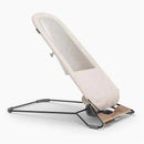 Uppababy Mira 2-in-1 bouncer and seat in sand mélange color, featuring a silver frame and birch wood base.