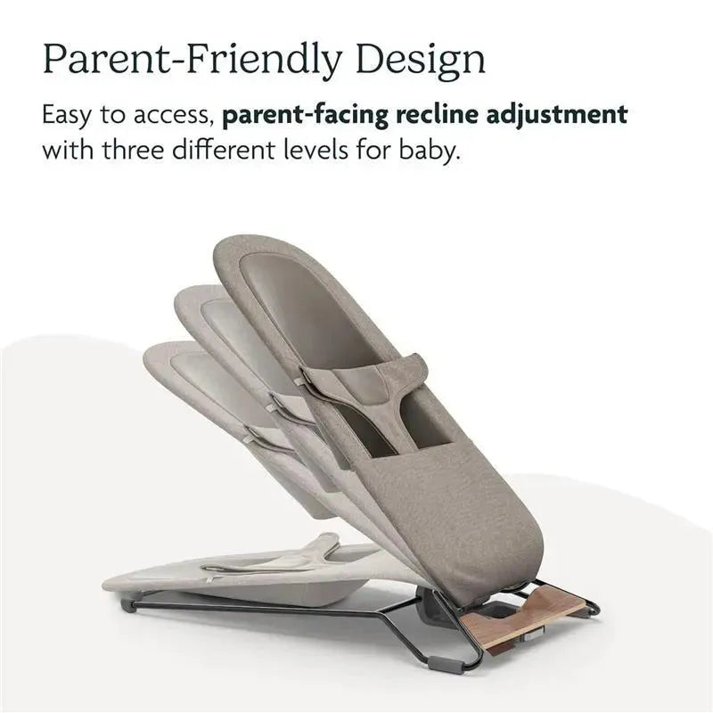 Parent-facing bouncer with three adjustable recline levels, featuring a soft grey fabric and a wooden base.