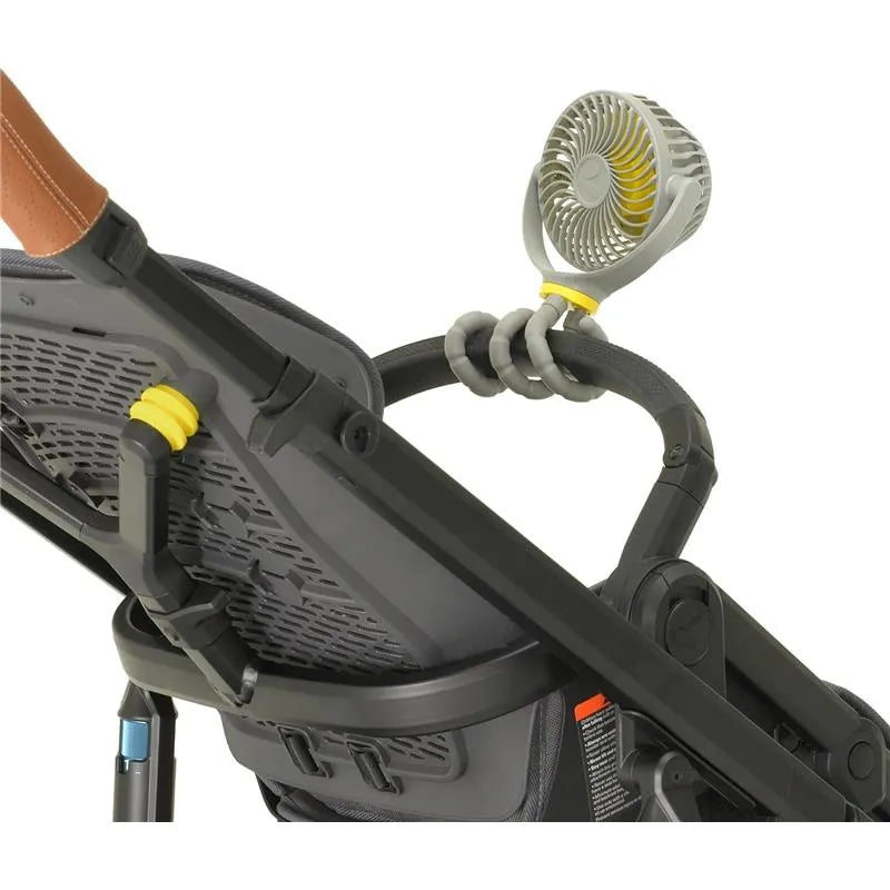 Portable baby stroller fan attached to the handle of a Veer Flex stroller, showcasing its adjustable design and airflow features.
