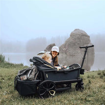 Rear foldable storage basket for Veer All-Terrain Cruiser, featuring a child and a smiling woman near a lake.