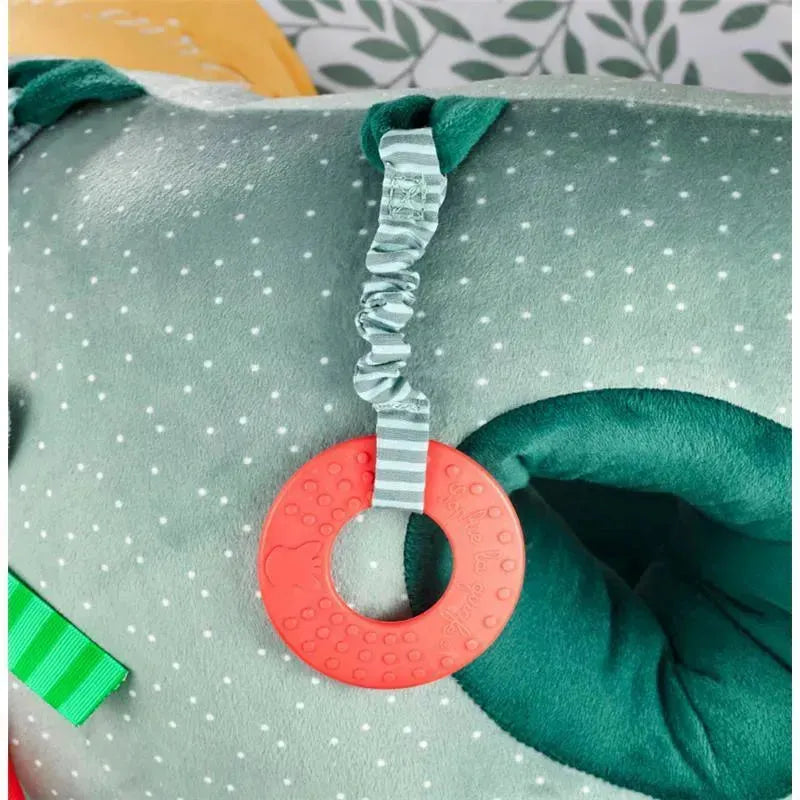 Red teething ring attached to a soft baby seat with polka dots, part of the Vulli Sophie La Girafe collection.