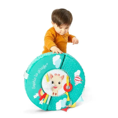 Toddler engaging with the Vulli Motor Skills Wheel, featuring a colorful design with Sophie the Giraffe and interactive elements.