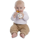 Baby sitting on the floor, grasping a Vulli Sophie La Girafe Sweetie Plush Rattle with a yellow teething toy attached.