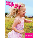 A joyful young girl with curly hair and a red grosgrain hair bow runs outdoors, wearing a pink floral dress.