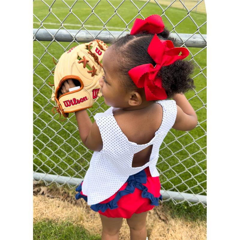 Red grosgrain hair bow with scalloped edges worn by a girl holding a Wilson baseball glove, standing by a fence.