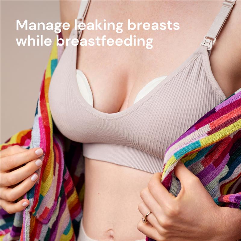 Reusable nursing pads displayed on a person wearing a beige nursing bra, promoting leak management during breastfeeding.