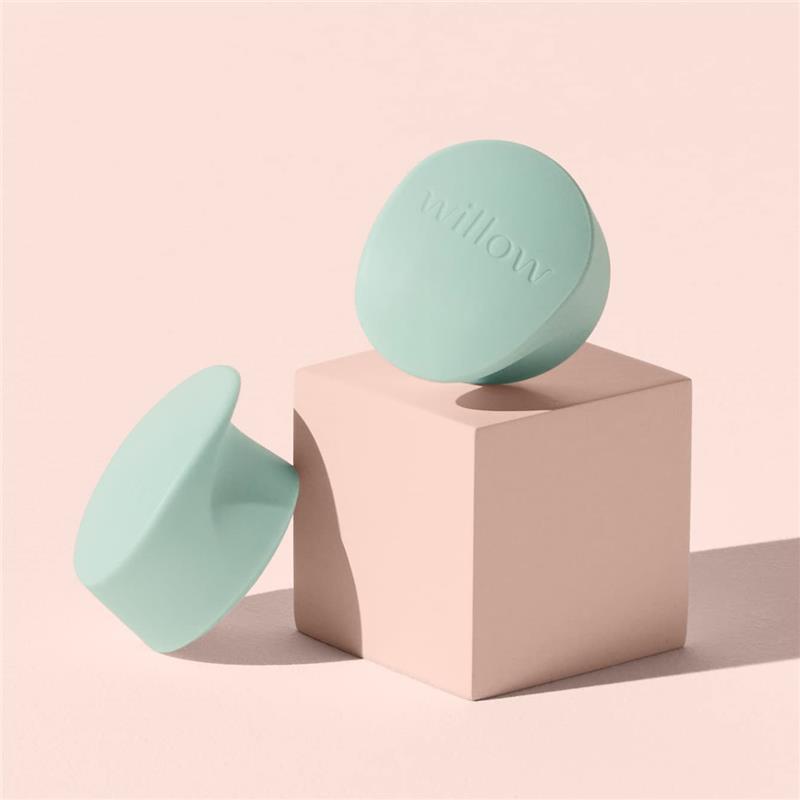 Duckbill valves in pastel mint color, designed for Willow containers, resting on a light pink cube.
