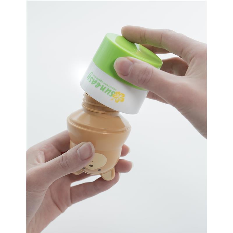 Sun-Easy sunscreen applicator shaped like a teddy bear in pink, being held with a green cap opened to dispense sunscreen.