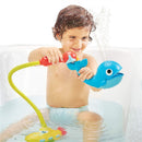 A child in a bathtub plays with the Yookidoo Submarine Spray Whale, which squirts water, enhancing bath time fun.