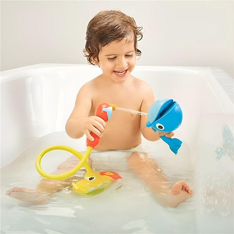 Toddler in a bathtub joyfully uses the Yookidoo Submarine Spray Whale toy to spray water.