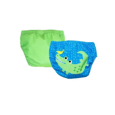 Two knit swim diapers from Zoocchini: one green and one blue featuring an alligator design with geometric patterns.