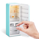 Miniature teal fridge playset with packaged food items and a hand reaching for a drawer.